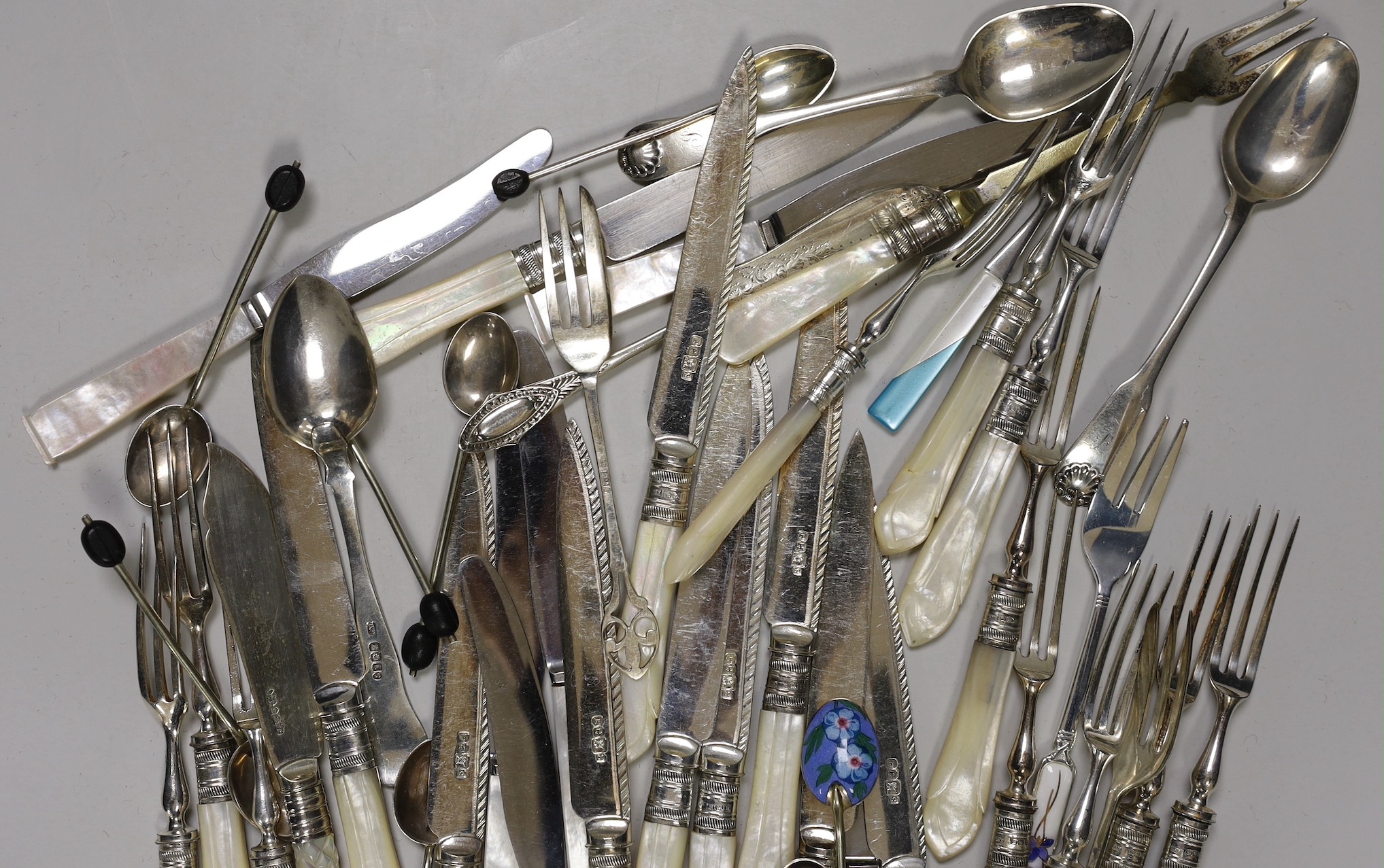 A selection of mounted mother-of-pearl knives and forks, together with finely decorated enamelled spoons